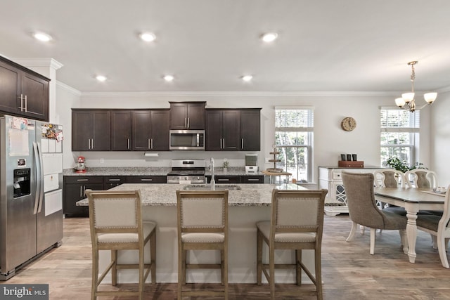 251 Rock Raymond Dr, Stafford, VA 22554 - kitchen featuring appliances with stainless steel finishes, a chandelier, dark brown cabinets, crown molding, and a breakfast bar