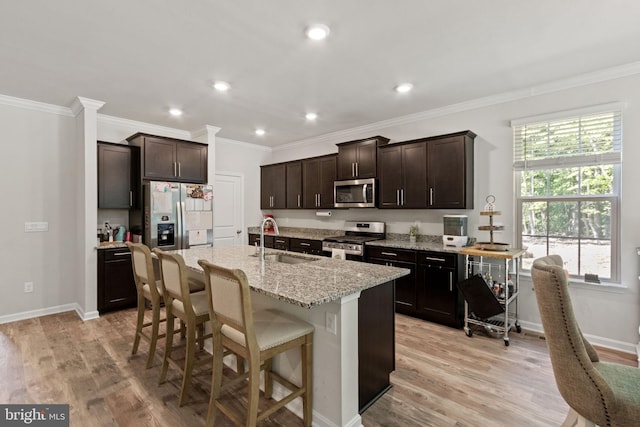 251 Rock Raymond Dr, Stafford, VA 22554 - kitchen with stainless steel appliances, a sink, light wood finished floors, ornamental molding, and dark brown cabinets