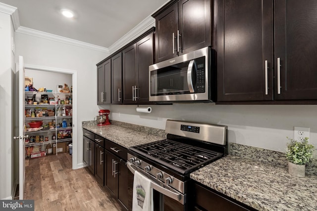 251 Rock Raymond Dr, Stafford, VA 22554 - kitchen with stainless steel appliances, crown molding, light wood finished floors, light stone counters, and dark brown cabinetry