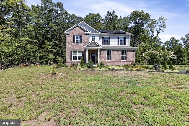 251 Rock Raymond Dr, Stafford, VA 22554 - traditional home featuring brick siding, solar panels, and a front lawn
