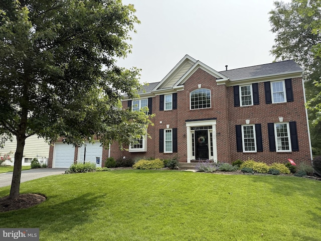 21526 Golden Autumn Pl, Broadlands, VA 20148 - colonial house with brick siding, driveway, a front lawn, and a garage