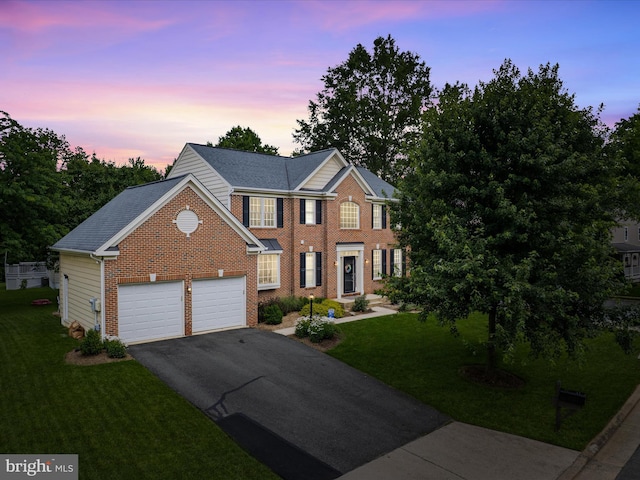 21526 Golden Autumn Pl, Broadlands, VA 20148 - view of front of home featuring asphalt driveway, an attached garage, brick siding, and a yard