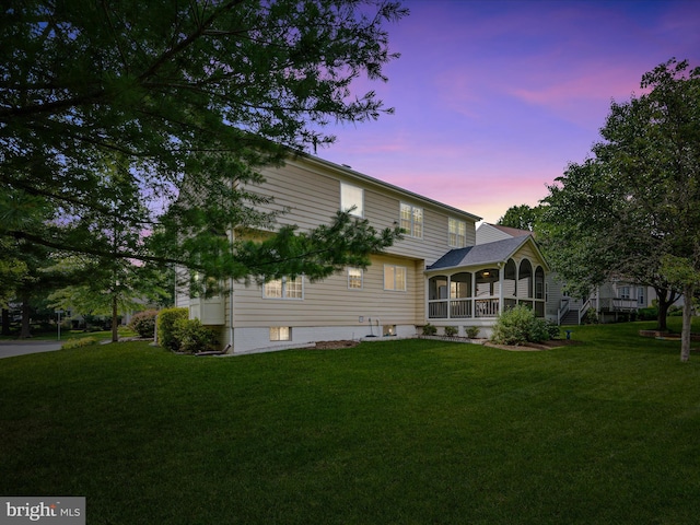 21526 Golden Autumn Pl, Broadlands, VA 20148 - back of house at dusk with a sunroom and a lawn