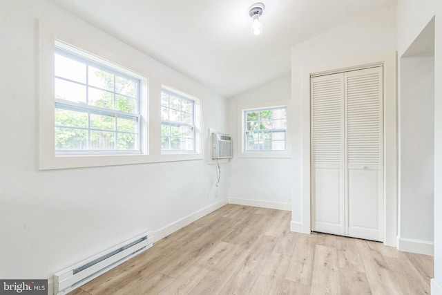 309 Bayview Rd, Edgewater, MD 21037 - unfurnished bedroom with a baseboard radiator, a wall mounted AC, lofted ceiling, light wood-style flooring, and a closet