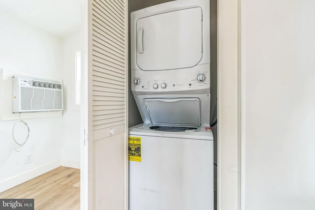 309 Bayview Rd, Edgewater, MD 21037 - laundry area featuring stacked washer / dryer, a wall mounted air conditioner, wood finished floors, and baseboards