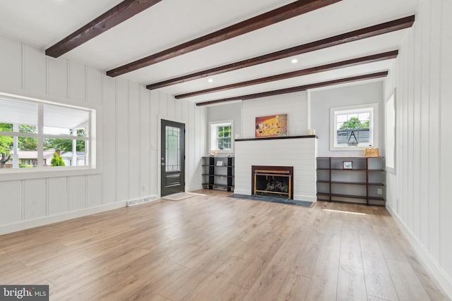 309 Bayview Rd, Edgewater, MD 21037 - unfurnished living room with wood finished floors, a brick fireplace, beam ceiling, healthy amount of natural light, and a decorative wall