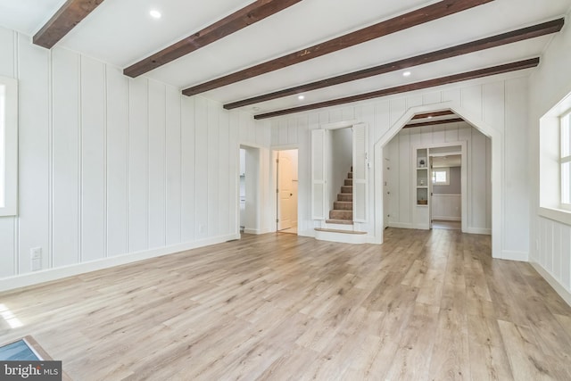 309 Bayview Rd, Edgewater, MD 21037 - unfurnished living room featuring light wood finished floors, arched walkways, beam ceiling, and stairs