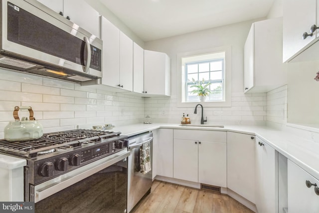 309 Bayview Rd, Edgewater, MD 21037 - kitchen featuring stainless steel appliances, a sink, light countertops, and white cabinetry