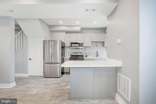 2915 Baker St, Baltimore, MD 21216 - kitchen with appliances with stainless steel finishes, a sink, a peninsula, light countertops, and light wood-style floors