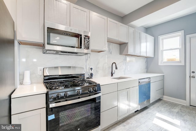 2915 Baker St, Baltimore, MD 21216 - kitchen featuring appliances with stainless steel finishes, a sink, tasteful backsplash, and light countertops