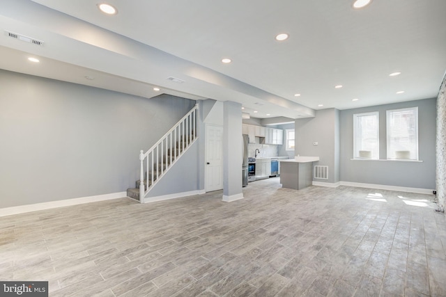 2915 Baker St, Baltimore, MD 21216 - unfurnished living room featuring stairs, baseboards, light wood-style flooring, and recessed lighting