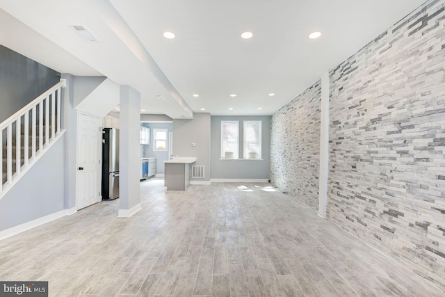 2915 Baker St, Baltimore, MD 21216 - unfurnished living room featuring recessed lighting, stairs, light wood-style floors, an accent wall, and baseboards