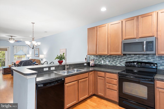 101 Colonial Downs Ct Unit 1305, Newark, DE 19702 - kitchen featuring black appliances, a sink, a peninsula, light wood-style floors, and a chandelier