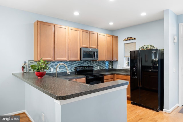 101 Colonial Downs Ct Unit 1305, Newark, DE 19702 - kitchen featuring black appliances, a peninsula, dark countertops, tasteful backsplash, and light wood-style floors