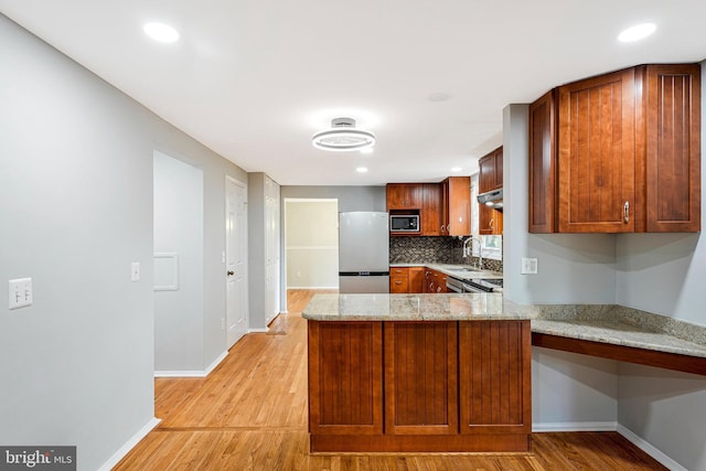 3414 Tyburn Tree Ct, Herndon, VA 20171 - kitchen featuring appliances with stainless steel finishes, a peninsula, baseboards, light wood-type flooring, and a sink
