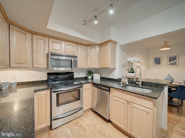 1715 15th St NW Unit 23, Washington, DC 20009 - kitchen with stainless steel appliances, light brown cabinets, a sink, a peninsula, and dark stone counters