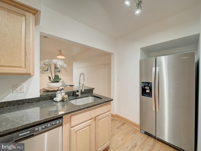 1715 15th St NW Unit 23, Washington, DC 20009 - kitchen featuring stainless steel appliances, light brown cabinets, a sink, light wood-style floors, and dark stone counters