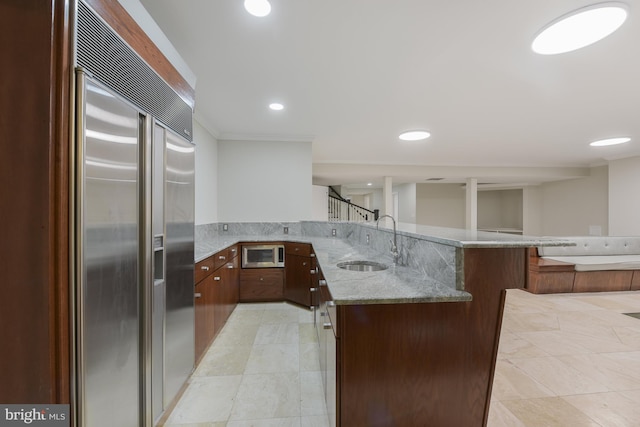 1496 Evans Farm Dr, Mclean, VA 22101 - kitchen featuring built in appliances, a peninsula, a sink, light stone countertops, and recessed lighting