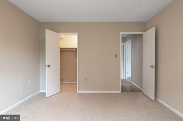1200 S Arlington Ridge Rd Unit 205, Arlington, VA 22202 - unfurnished bedroom featuring carpet, a walk in closet, baseboards, and a closet
