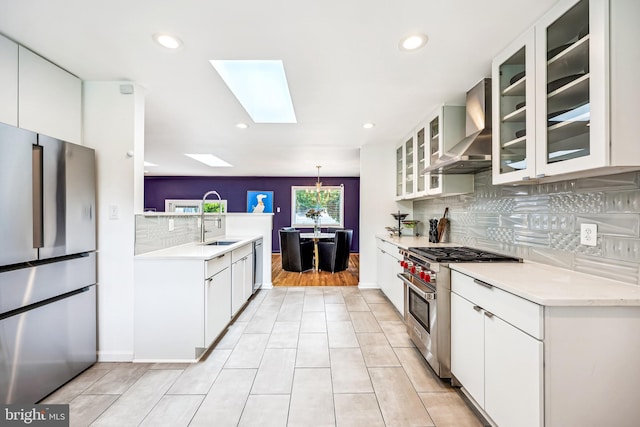 11700 Seven Locks Rd, Potomac, MD 20854 - kitchen featuring appliances with stainless steel finishes, wall chimney range hood, a sink, tasteful backsplash, and a skylight