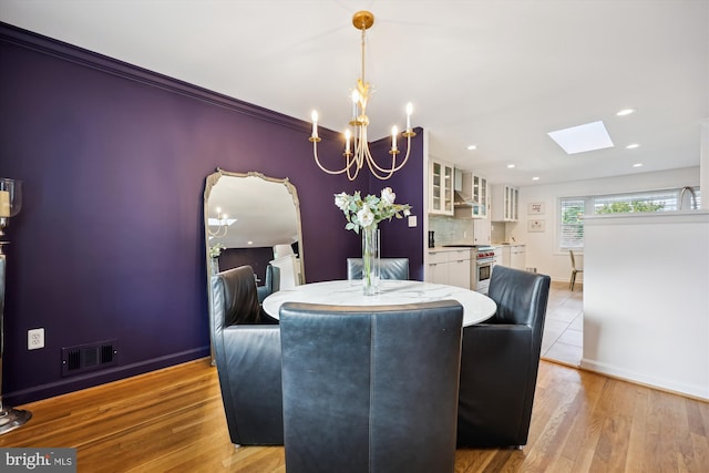11700 Seven Locks Rd, Potomac, MD 20854 - dining area with a chandelier, baseboards, a skylight, light wood finished floors, and recessed lighting