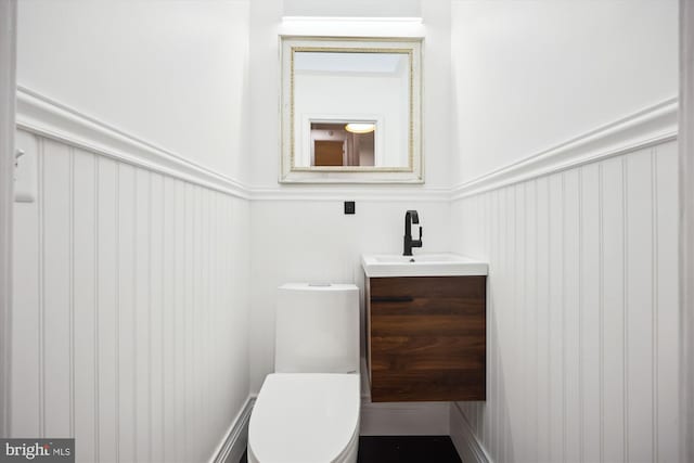 11700 Seven Locks Rd, Potomac, MD 20854 - half bathroom featuring vanity, toilet, and a wainscoted wall