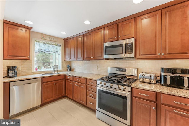 515 Terravilla Ln, Ridley Park, PA 19078 - kitchen with stainless steel appliances, a sink, brown cabinets, light tile patterned floors, and backsplash