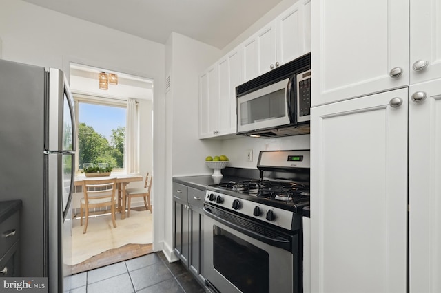 4000 Tunlaw Rd NW Unit 714, Washington, DC 20007 - kitchen featuring appliances with stainless steel finishes, dark tile patterned floors, and white cabinetry
