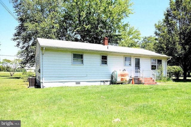 21749 Point Lookout Rd, Leonardtown, MD 20650 - back of house with oil tank, a lawn, cooling unit, crawl space, and a chimney