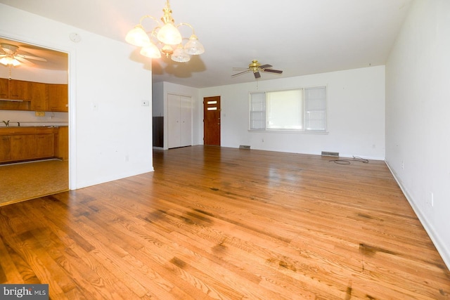 21749 Point Lookout Rd, Leonardtown, MD 20650 - unfurnished living room with ceiling fan, wood finished floors, a chandelier, a sink, and baseboards