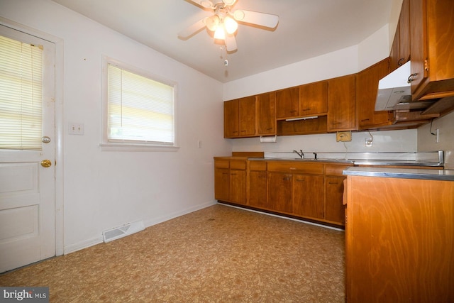21749 Point Lookout Rd, Leonardtown, MD 20650 - kitchen with a ceiling fan, baseboards, open shelves, brown cabinetry, and a sink
