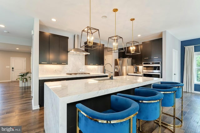 24824 Scarlet Maple Ct, Aldie, VA 20105 - kitchen with wall chimney range hood, appliances with stainless steel finishes, a sink, dark wood-style flooring, and backsplash