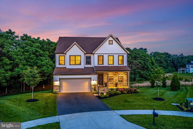 24824 Scarlet Maple Ct, Aldie, VA 20105 - view of front of house featuring driveway, a front lawn, a porch, an attached garage, and stone siding
