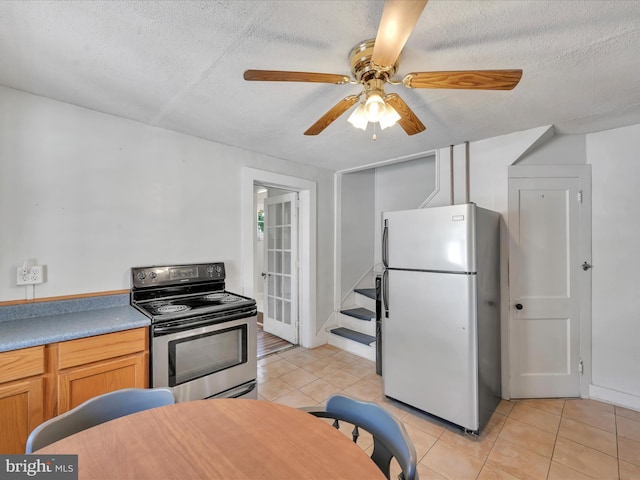 415 Parkway Ave, Schuylkill Haven, PA 17972 - kitchen featuring freestanding refrigerator, stainless steel electric range oven, light tile patterned flooring, ceiling fan, and a textured ceiling
