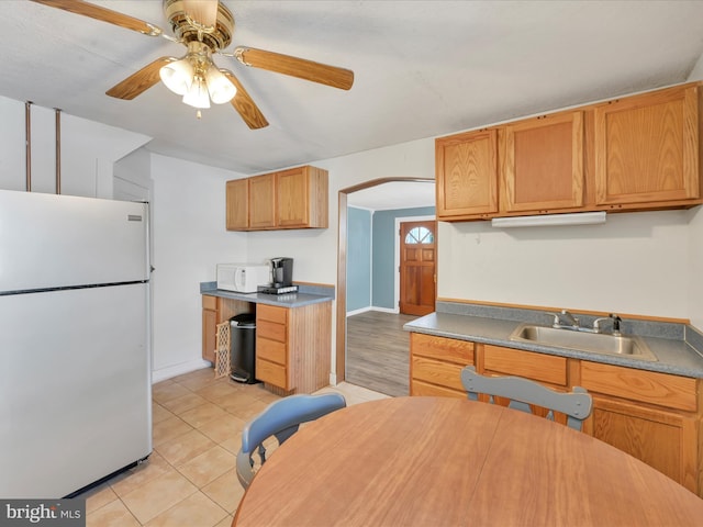 415 Parkway Ave, Schuylkill Haven, PA 17972 - kitchen with freestanding refrigerator, a sink, ceiling fan, light tile patterned flooring, and arched walkways