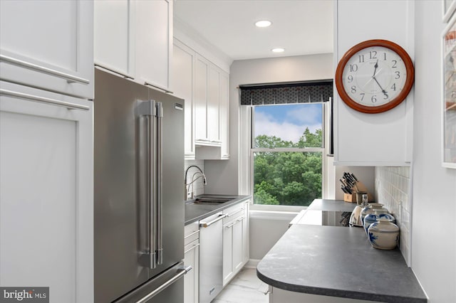 3601 Connecticut Ave NW Unit 816, Washington, DC 20008 - kitchen with appliances with stainless steel finishes, white cabinets, recessed lighting, backsplash, and light marble finish floors
