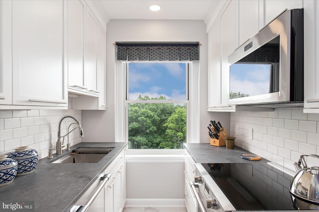 3601 Connecticut Ave NW Unit 816, Washington, DC 20008 - kitchen featuring stove, white cabinetry, backsplash, dark countertops, and recessed lighting