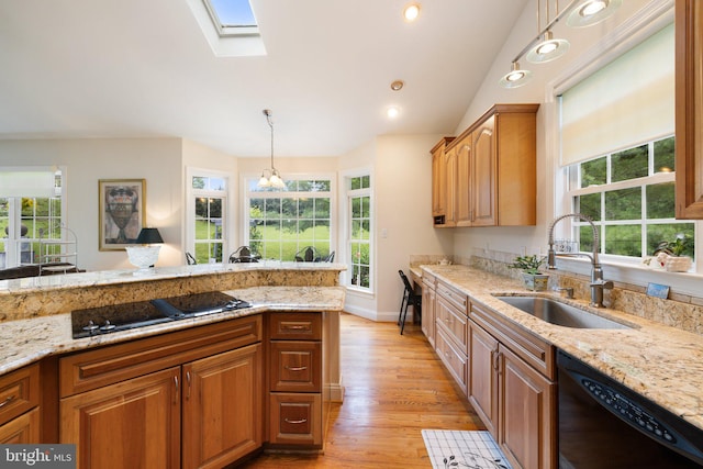 1399 N Royal Ave, Front Royal, VA 22630 - kitchen with black appliances, a sink, light wood finished floors, a skylight, and light stone counters