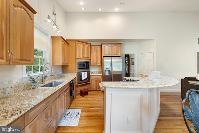 1399 N Royal Ave, Front Royal, VA 22630 - kitchen featuring black appliances, a sink, light wood-type flooring, a center island, and light stone countertops