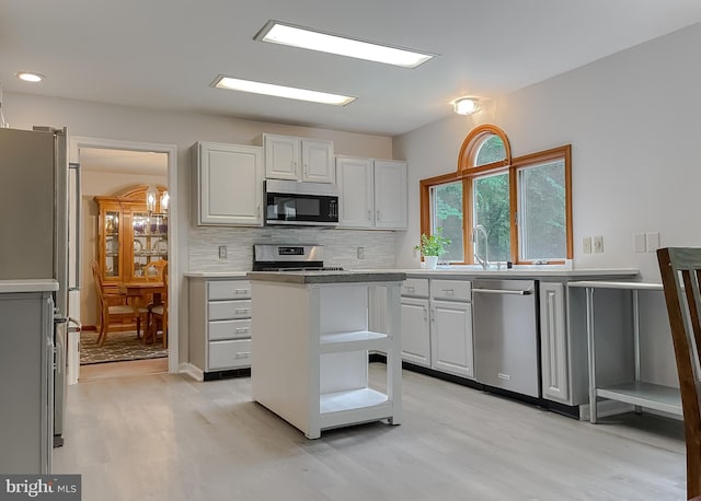 41920 Clover Hill Ct, Hollywood, MD 20636 - kitchen featuring appliances with stainless steel finishes, light wood-type flooring, decorative backsplash, a sink, and light countertops