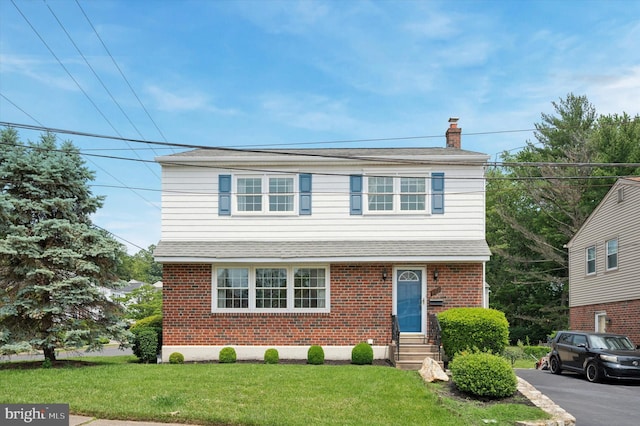 167 Eldon Ave, Lansdowne, PA 19050 - view of front of house featuring a chimney, brick siding, a front yard, entry steps, and roof with shingles