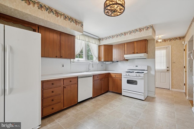 167 Eldon Ave, Lansdowne, PA 19050 - kitchen with white appliances, under cabinet range hood, light countertops, and brown cabinets