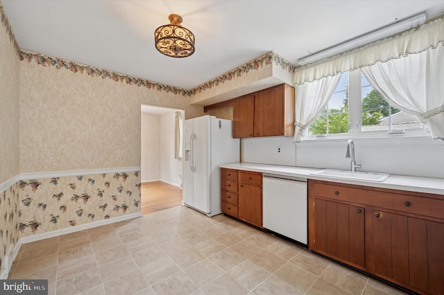 167 Eldon Ave, Lansdowne, PA 19050 - kitchen with white appliances, wallpapered walls, a sink, light countertops, and brown cabinets