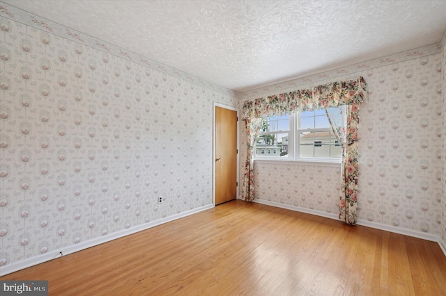 167 Eldon Ave, Lansdowne, PA 19050 - unfurnished room with wood finished floors, a textured ceiling, baseboards, and wallpapered walls