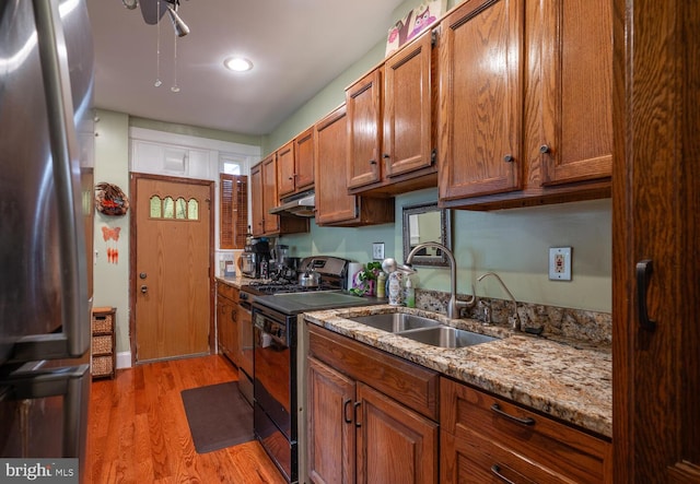 4800 Illinois Ave NW, Washington, DC 20011 - kitchen with freestanding refrigerator, a sink, black range with electric cooktop, under cabinet range hood, and brown cabinetry
