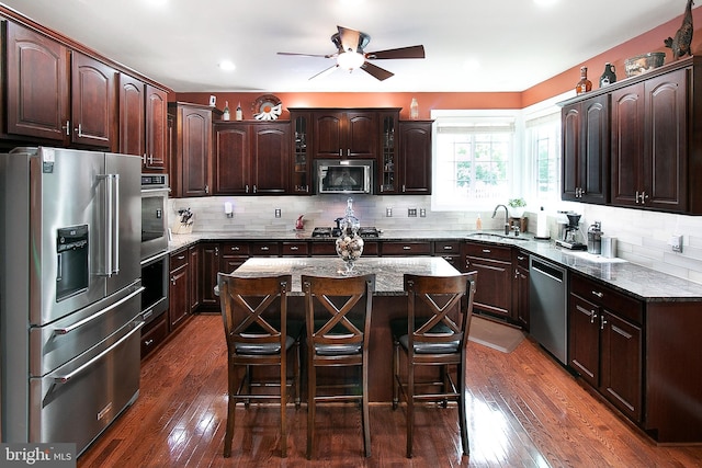 13763 Deacons Way, Gainesville, VA 20155 - kitchen with stainless steel appliances, ceiling fan, decorative backsplash, a kitchen bar, and dark brown cabinets