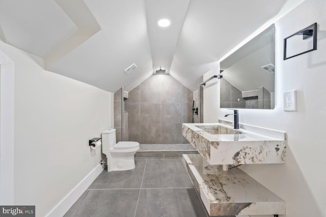 2908 Parkland Dr, District Heights, MD 20747 - bathroom featuring toilet, a tile shower, a sink, vaulted ceiling, and baseboards