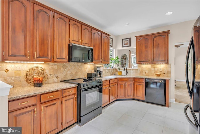 3026 5th St S, Voorhees, NJ 08043 - kitchen with black appliances, light stone counters, brown cabinets, a sink, and backsplash