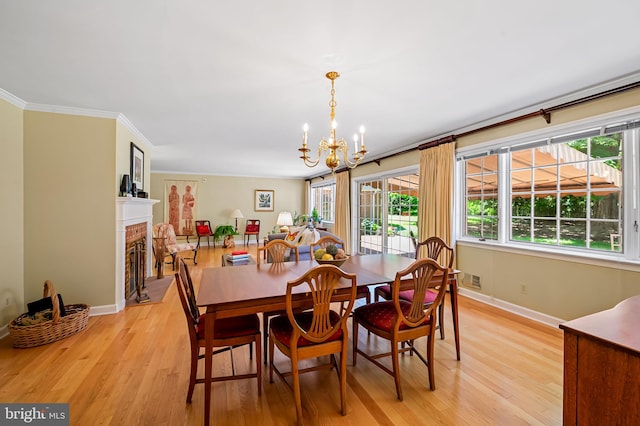 5702 Ainsley Garth, Baltimore, MD 21212 - dining area with light wood-type flooring, a chandelier, ornamental molding, and a brick fireplace