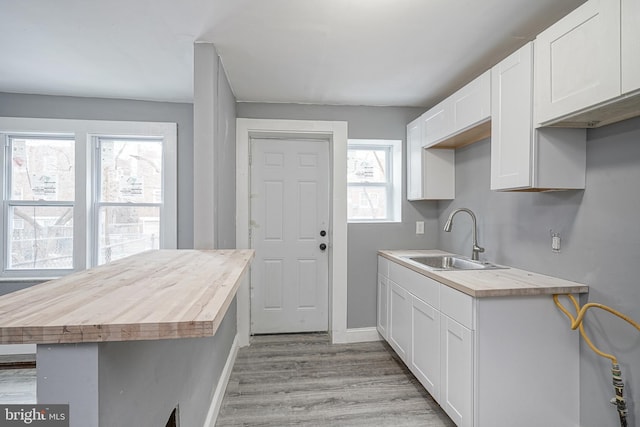 2933 Royden St, Camden, NJ 08105 - kitchen featuring a sink, light wood finished floors, butcher block countertops, and white cabinetry